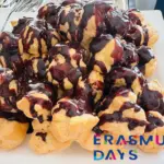 Csokoládéöntettel leöntött profiterolok tálon