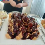 Felszolgáló profiterolokat rendez a tálon